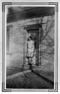 Mom in door of big adobe house